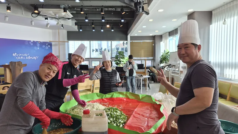 앞치마와 모자를 쓰고 김장을 함께 담그는 사람들