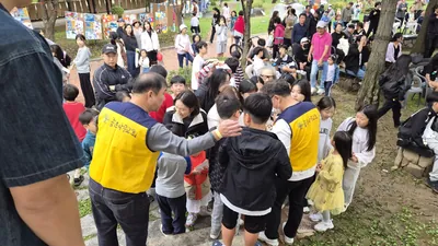 축제장에서 노란 조끼의 봉사자들과 모인 아이들