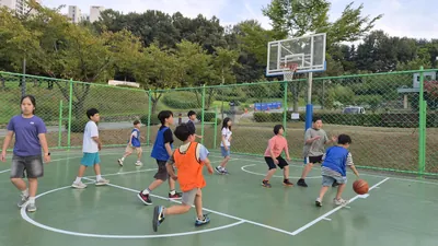 야외 농구 코트에서 함께 농구를 하는 아이들