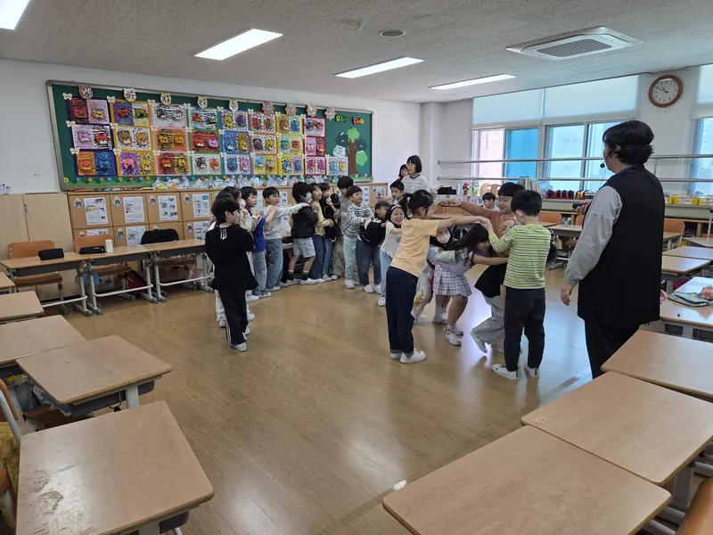 교실에서 전래놀이 강사와 함께 둥글게 모인 아이들