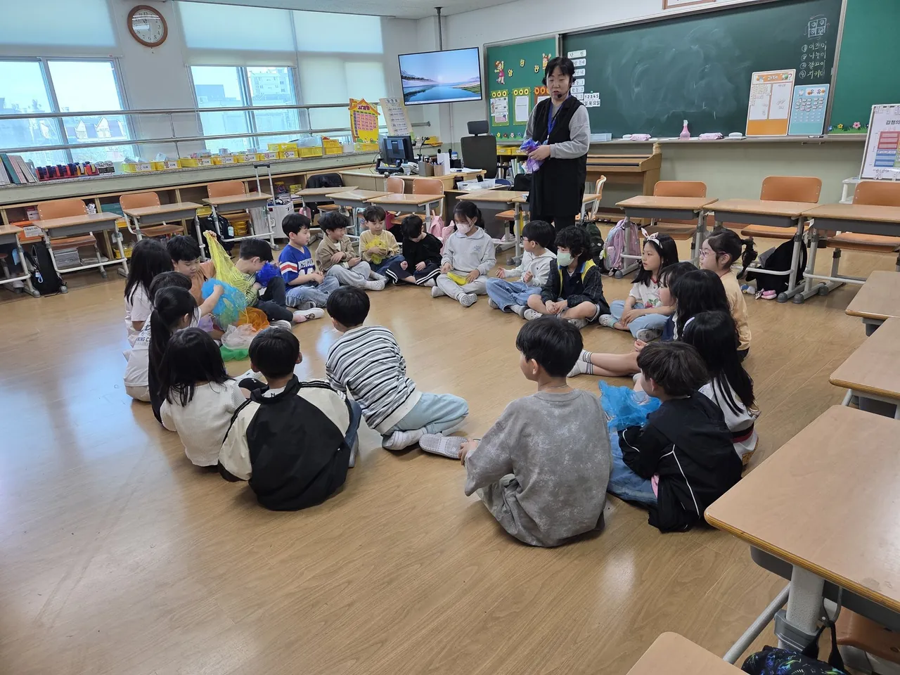 교실 바닥에 둘러앉아 전래놀이 강사의 안내를 듣는 아이들