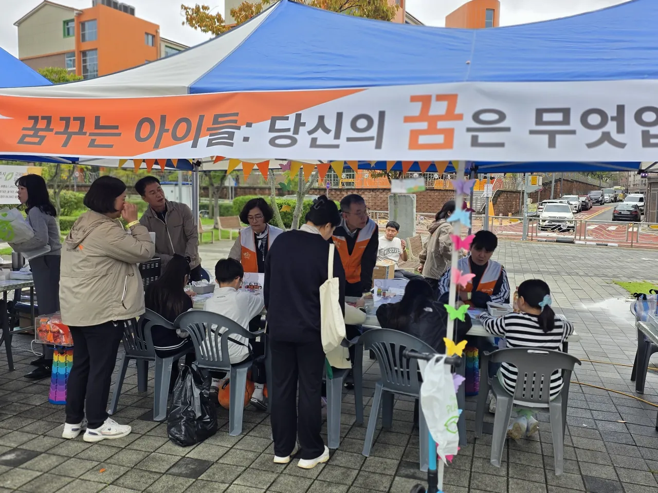 '꿈꾸는 아이들' 현수막이 걸린 축제 천막 부스와 사람들