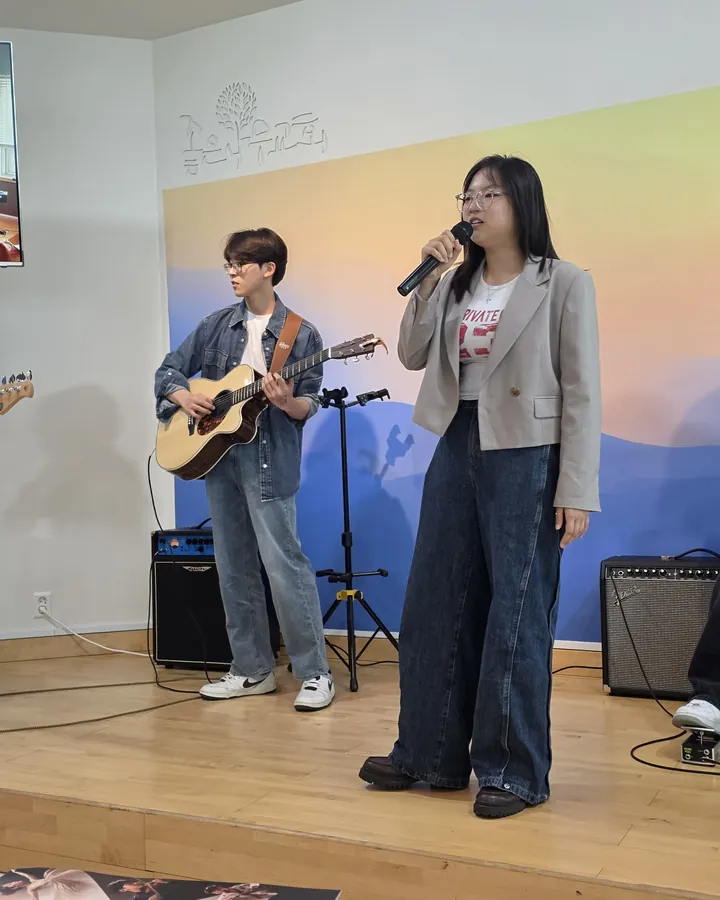 무대에서 기타를 치며 노래하는 청소년들