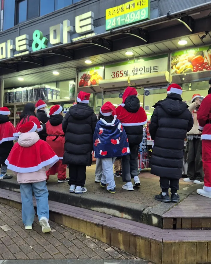 산타 복장을 하고 상가 앞에 모인 아이들과 어른들