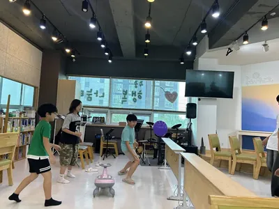 교회 홀에서 풍선을 쳐 올리며 노는 아이들