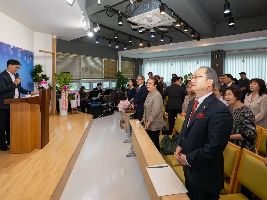 강대상 앞에 선 목사와 일어서서 예배하는 교인들